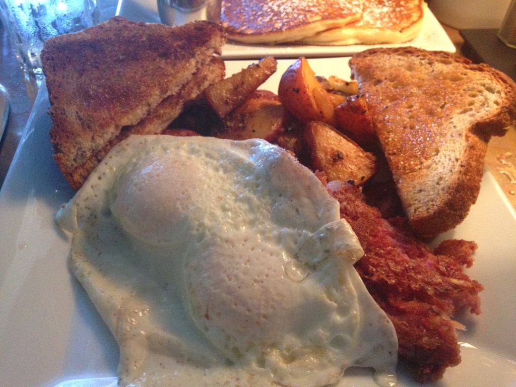 Corned beef hash hiding beneath perfectly cooked over-easy eggs.
